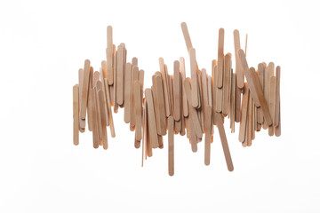 Many wooden ice cream sticks in chaotically row on white background isolated, flat lay