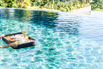 Floating breakfast in infinity pool on paradise island Bali. Luxury life