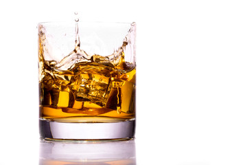 Whiskey glass with splash, isolated on white background