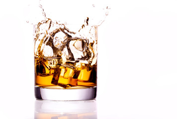 Whiskey glass with splash, isolated on white background
