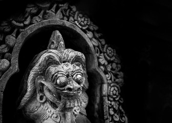 Traditional balinese demon statue isolated on black background with copy space
