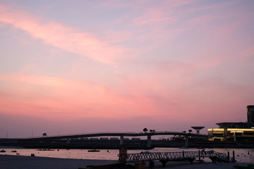 Fototapeta na wymiar beautiful pink sunset sky near the seashore with some marshmellow clouds on it.