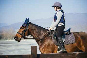 little girl riding her horse in the paddock - little girl taking riding lesson -