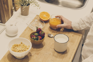 Hombre con zumo de naranja y taza con leche