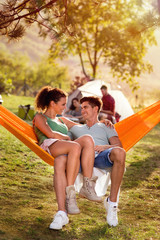 young couple on camping trip in hammock chair