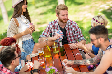 Playing cards outdoor with drinks and friends