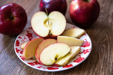 Naklejka na ściany i meble Fresh organic big red apples whole and sliced on wooden table