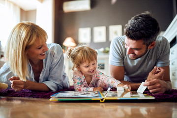 Mom and dad play with their kid in room