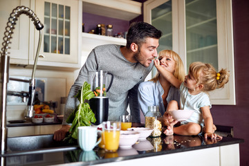 Girl feeding her father in kitchen