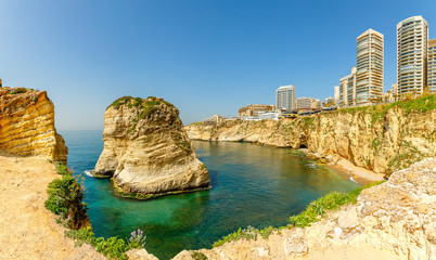 Fototapeta premium Raouche lub gołębie panorama skał z morzem i kruchym centrum w tle, Bejrut, Liban