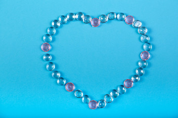 Heart of beads and pebbles on a blue background.