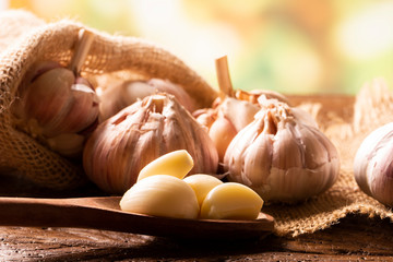 Garlic close up, Garlic bulb, Garlic cloves in jute sack on wooden background.