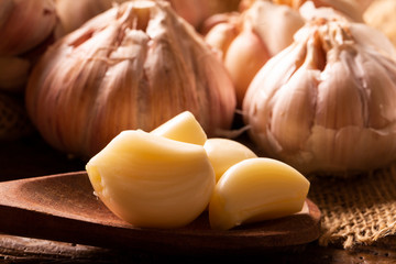 Garlic close up, Garlic bulb, Garlic cloves in jute sack on wooden background.