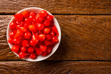 Biquinho Pepper into a bowl. Capsicum Chinense over a wooden table