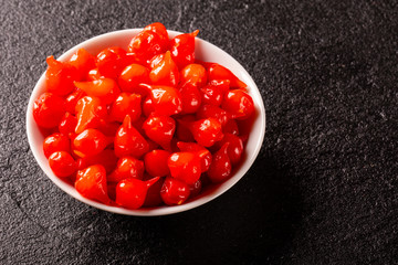 Biquinho Pepper into a bowl. Capsicum Chinense over a wooden table