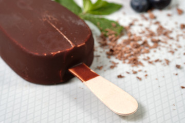 chocolate butter ice cream popsicles on the white plate with fresh summer berries, strawberries, blueberries