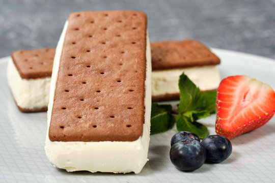 vanilla ice cream with cookies on a white plate with berries