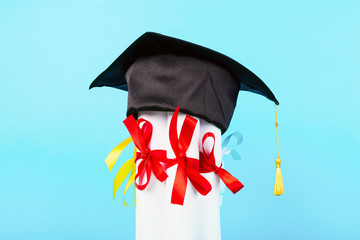 graduation cap on diplomas, image on blue background