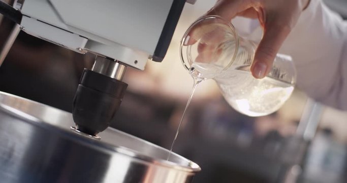 Unknown fluid dripping out of erlenmeyer flask into a metal bowl