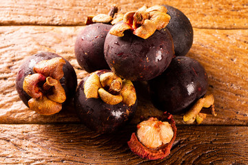 Thai fruit : Mangosteen is queen of fruits. Organic fruit in the basket. Fresh mangosteens on wooden table. Selective focus.