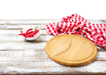 Round pizza cutting board red chili peper and tablecloth on wooden background. Top view. Copy space and mock up. Place for food and drink. Picnic and thanksgiving day concept.