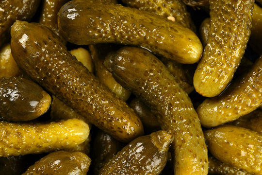 Top view, extreme close up of pickled gherkins (small cucumbers). Macro food texture background with pickles