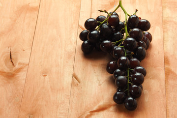 Black grapes on a wooden table