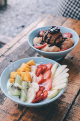 fresh strawberries,Bowl of homemade yogurt with fresh strawberry,banana,apple,kiwi and mango on wooden background from top view 