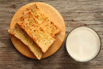 Milk with homemade Herb and Garlic Bread on wood table.Top view.