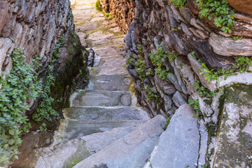 Greece, Kea island. Ioulis city narrow street with stairs and traditional stone walls