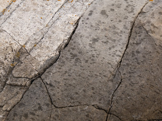 Cracked granite rock texture spotted with rain drops