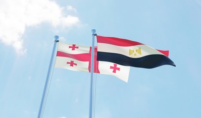 Georgia and Egypt, two flags waving against blue sky. 3d image