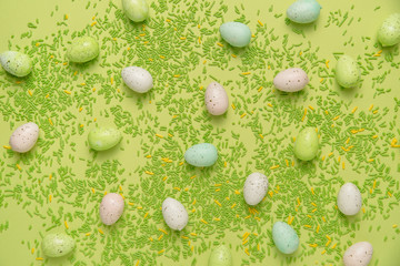 Flat lay of eggs and sprinkles on green