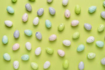 Flat lay of scattered eggs on a bright green background