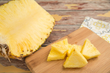 Freshly sliced pineapple on a bamboo cutting board