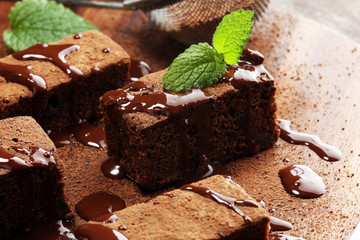 Brownie dessert. Cake chocolate brownies on wooden background with mint.