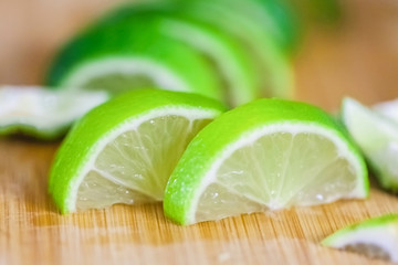 lime slices on wooden table, close up blurry background