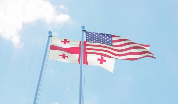 Georgia and USA, two flags waving against blue sky. 3d image