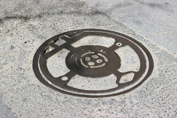 Old aged manhole cover asphalt surface texture