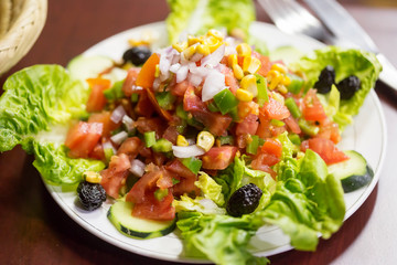 Traditional moroccan salad with cucumbers, tomatoes, peppers, olives & lettuce