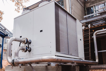 Industrial stainless steel pipes connected to the commercial cooling unit for the HVAC systems