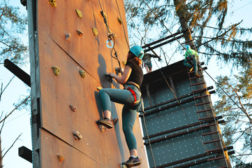 Fototapeta na wymiar Active young woman on rock wall in sport center - outdoors