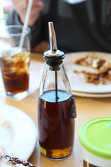 maple syrup in glass bottle on a table in a restaurant