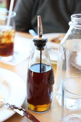 maple syrup in glass bottle on a table in a restaurant