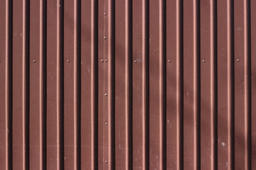 Corrugated brown metal fence surface texture