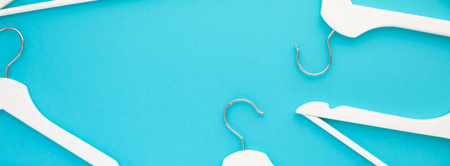 White wooden hangers on blue background