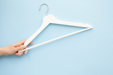 White wooden hangers on blue background