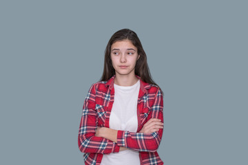 young teen girl looks puzzled, gray background
