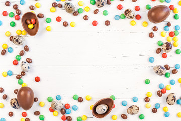 Easter frame with chocolate eggs, colorful candies