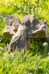 A fallen angel cross gravestone close up